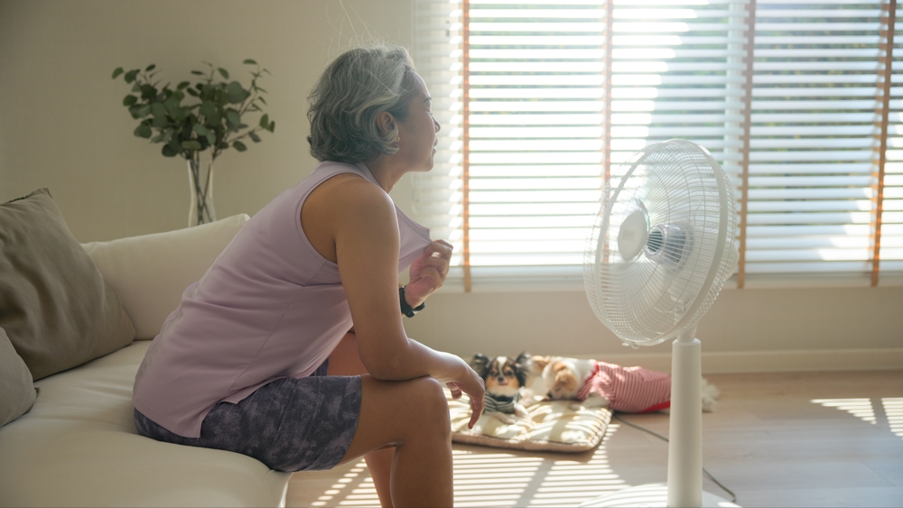 Middle age asian woman in front of fan