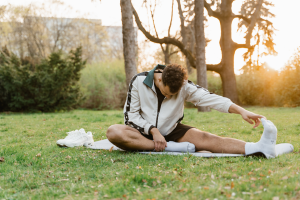 Young male stretching in park